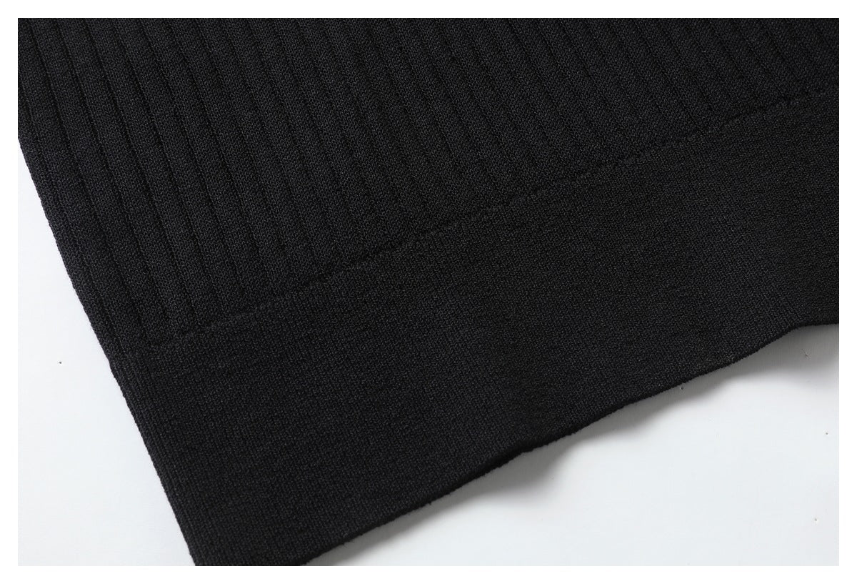 Close-up of the black top's ribbed body and wide finished hem.