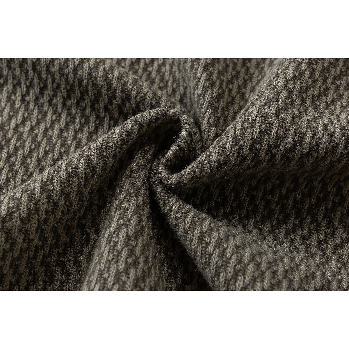 Macro view of the taupe-gray garment's textured knit, gathered into soft folds.