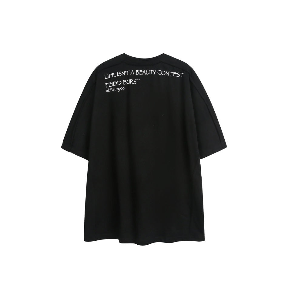 Back of a black oversized short-sleeve T-shirt with small white text printed across the upper back.