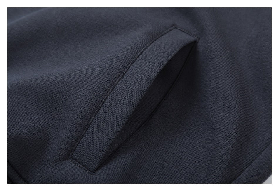 Close-up of a slanted pocket opening on a dark charcoal garment.