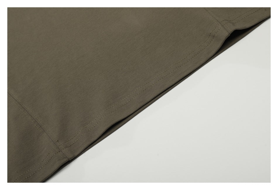 Close-up of the olive-brown T-shirt's double-stitched bottom hem and side seam.