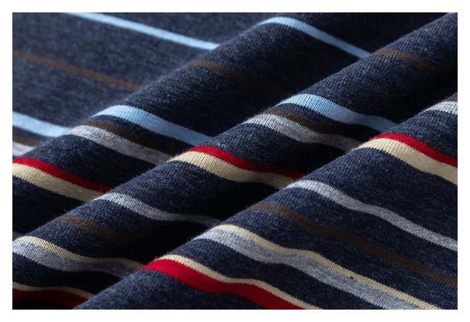 Close-up of navy knit fabric with red, cream, gray, brown, and light blue stripes.