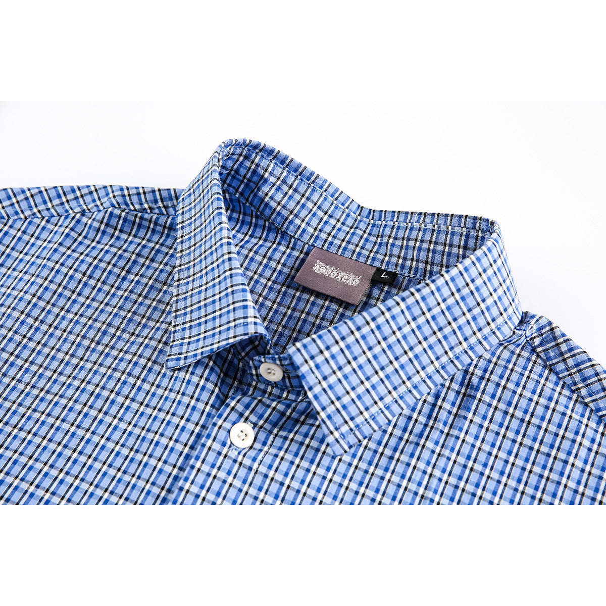 Close-up of a blue, white and black plaid shirt collar, buttons and inside neck label.