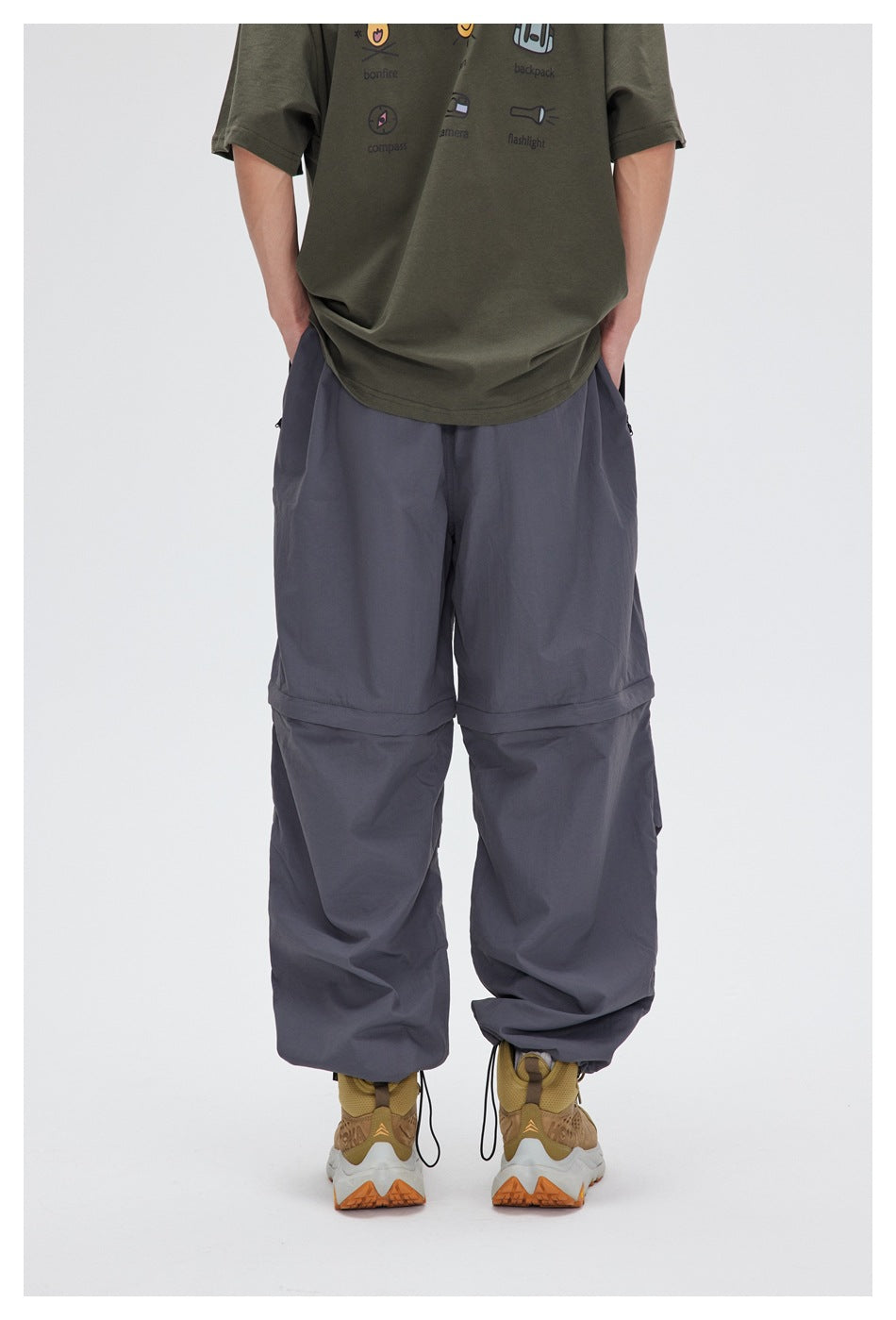 Rear view of a model wearing slate-gray convertible pants with gathered ankle hems.
