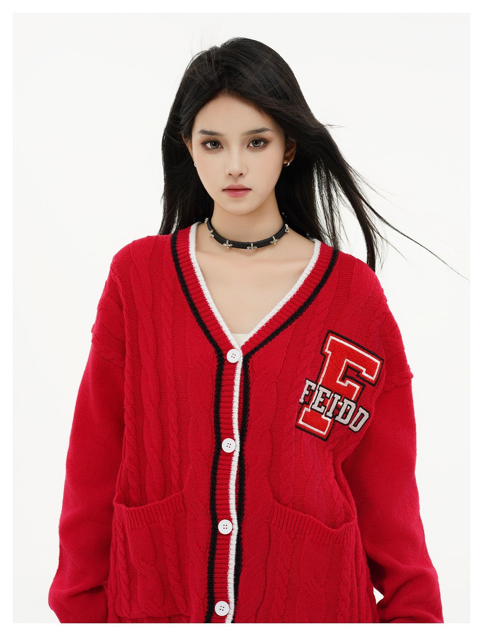 Model wearing a red cable-knit cardigan with striped V-neck trim, buttons, pockets and a letter F patch, close-up