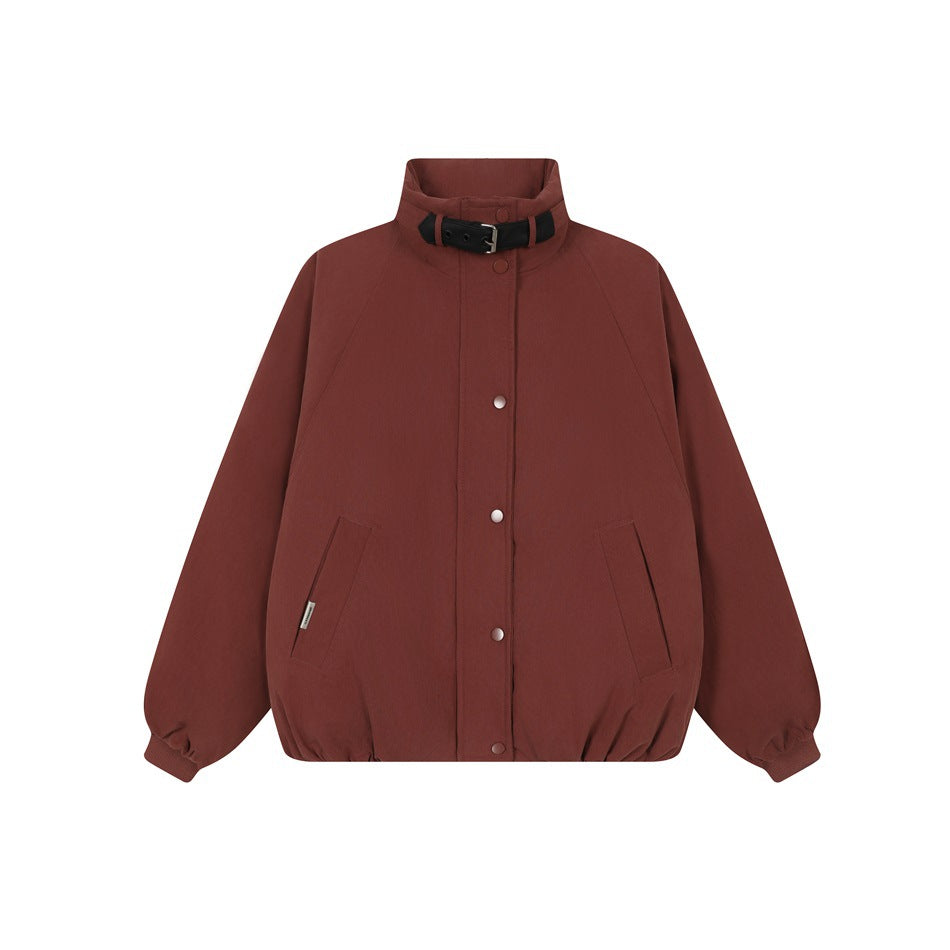 Burgundy stand-collar jacket with black buckled collar strap, snap front, raglan sleeves and front pockets, flat lay
