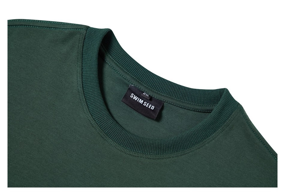 Close-up of the dark green T-shirt's ribbed crew neck and sewn-in SWIM SEED label.