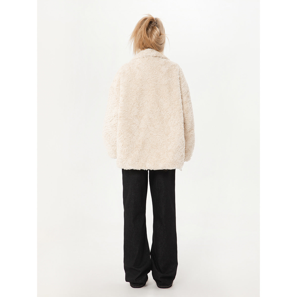 Full-length rear view of a model wearing an ivory textured coat and black wide-leg pants.