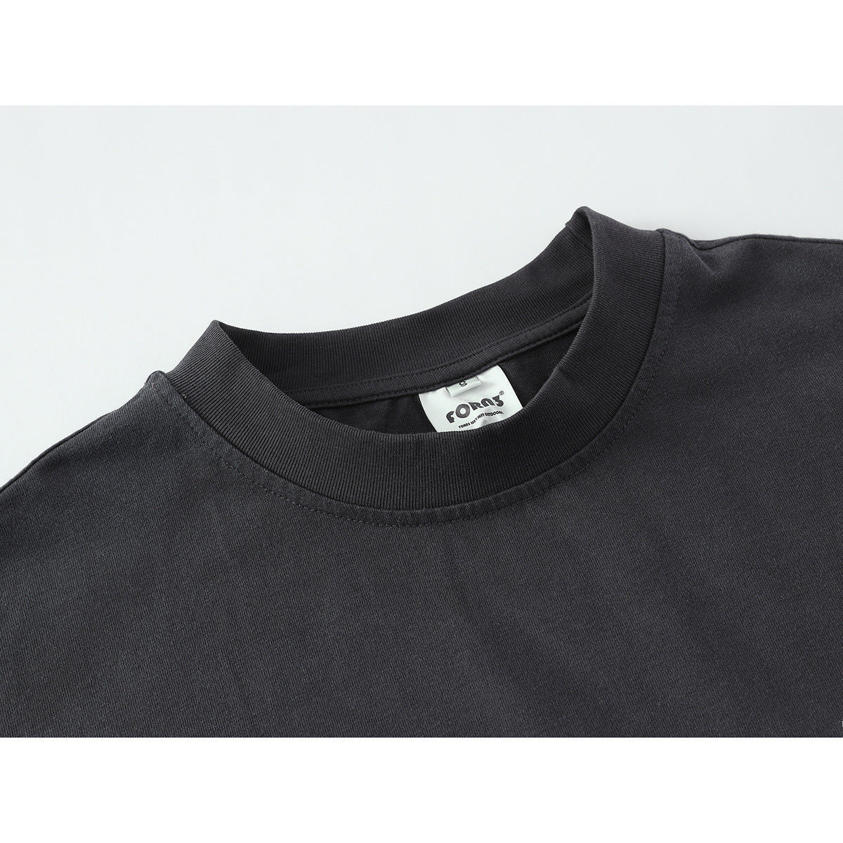 Close-up of a charcoal long-sleeve shirt's ribbed crew neck and inside label.