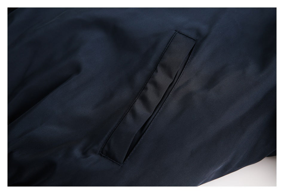 Close-up of a dark navy garment showing a narrow welt pocket and stitched seams.