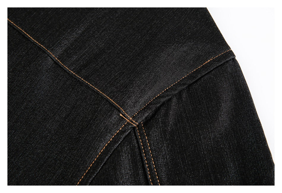 Close-up of intersecting tan-stitched seams on a dark black garment.