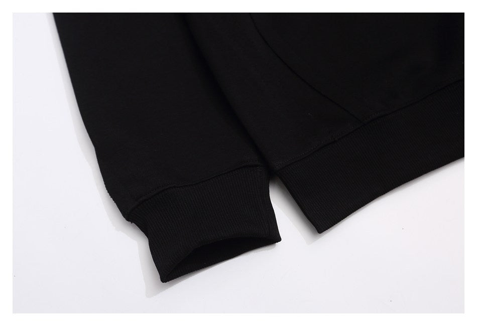 Close-up of a black sweatshirt sleeve cuff and ribbed lower hem.