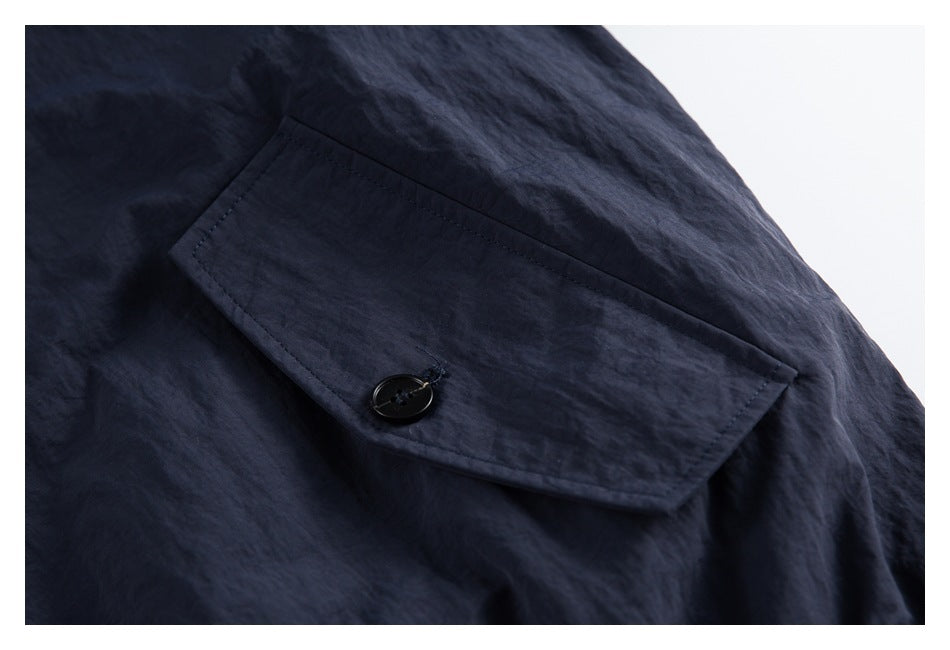Close-up of a dark navy flap pocket with a black button.