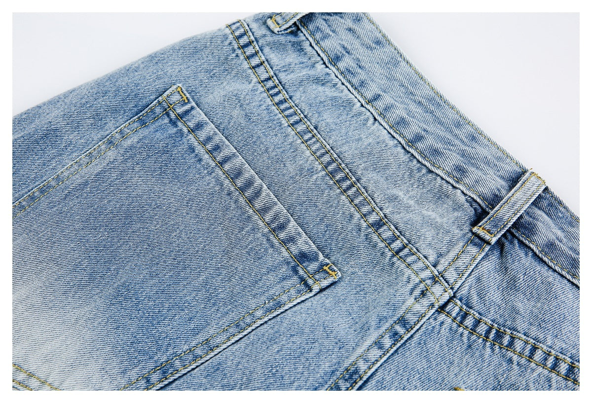 Close-up of light blue jeans showing a back pocket, waistband, belt loop, and yellow stitching.