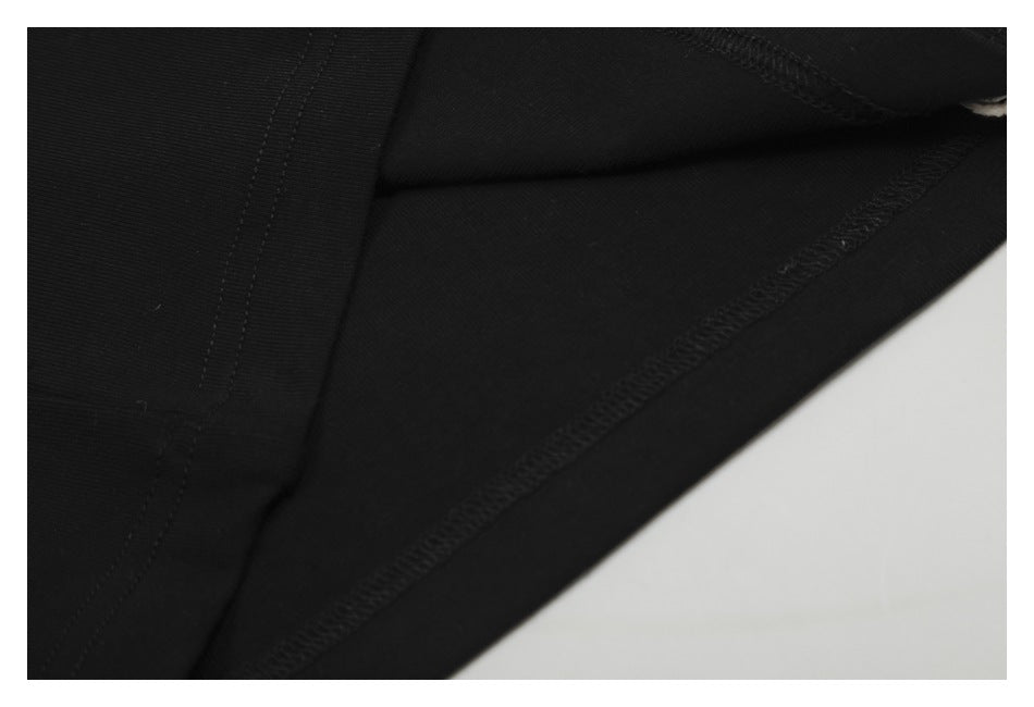 Close-up of the inside seams and overlocked stitching on black fabric.