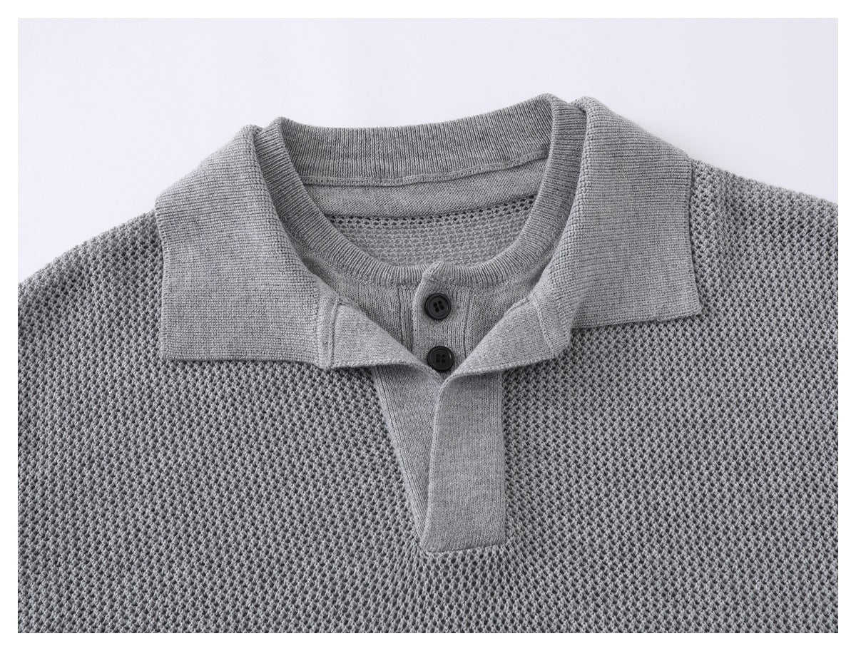 Close-up of a gray knit polo shirt's collar and two-button placket against its textured body.