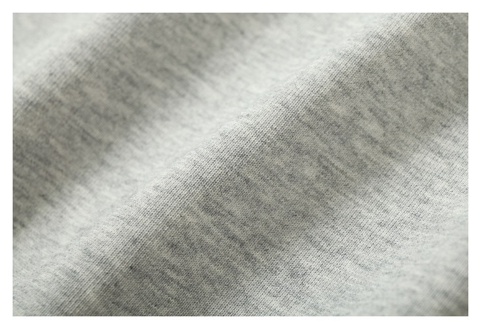 Close-up of light gray heathered knit fabric showing its fine texture and drape.