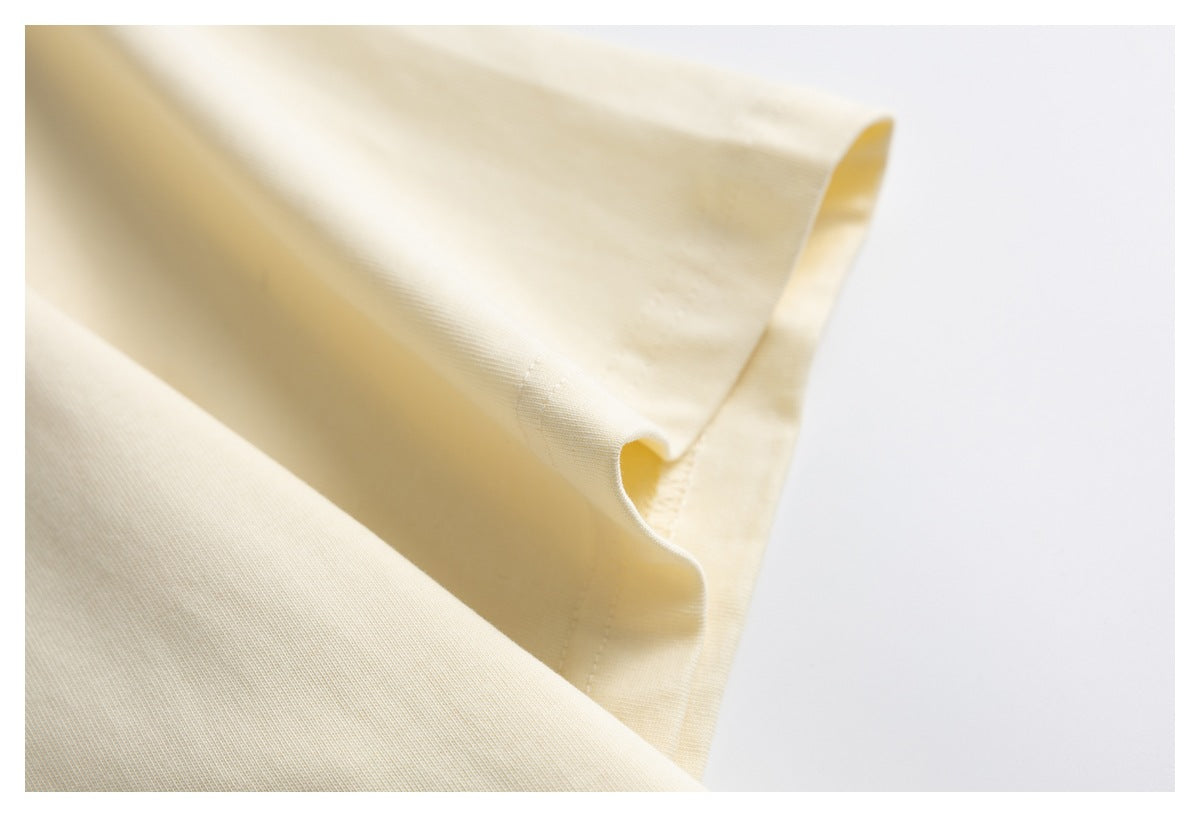 Close-up of cream fabric folded to show a stitched edge and seam.