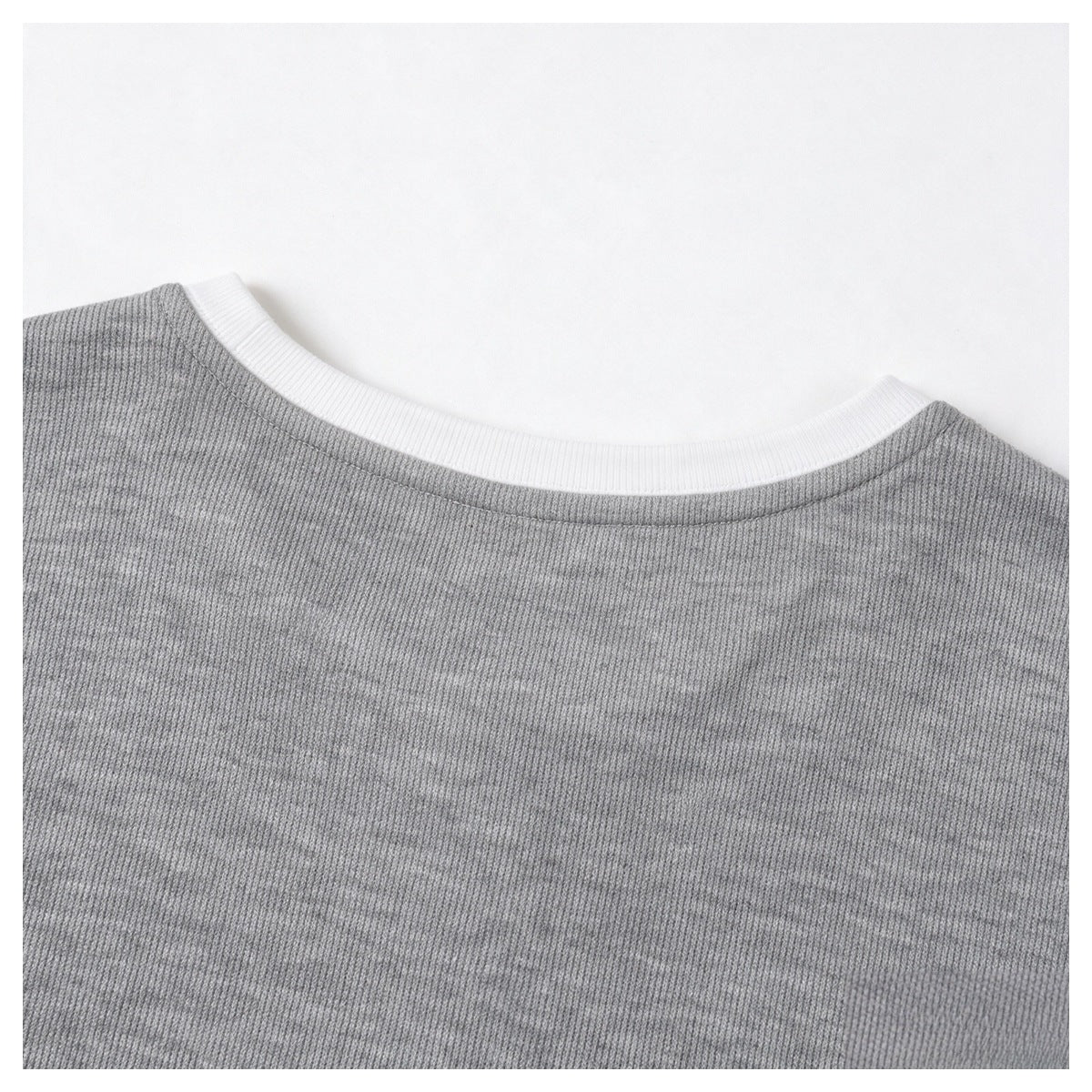 Close-up of the back neckline of a gray ribbed top, edged with white ribbed trim.