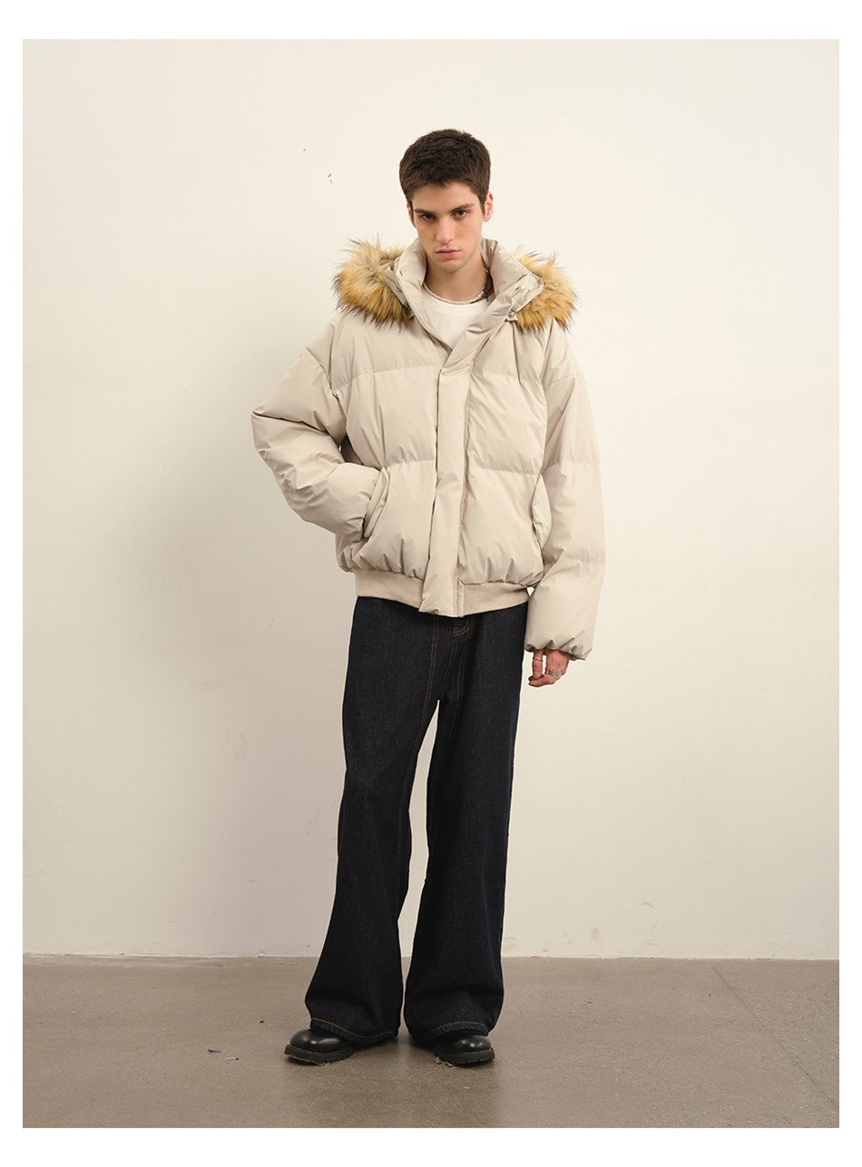 Full-length view of a model wearing a light beige hooded puffer jacket with tan fur trim and dark wide-leg jeans.