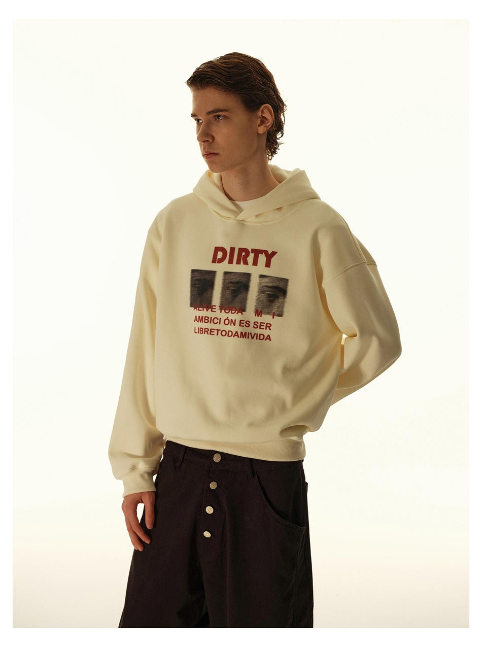 Closer view of a model wearing a cream hoodie with a red-and-black chest graphic.
