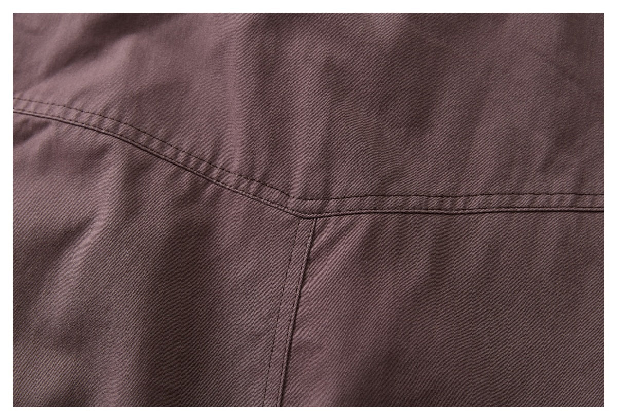 Close-up of mauve-brown jacket fabric showing stitched panel seams.