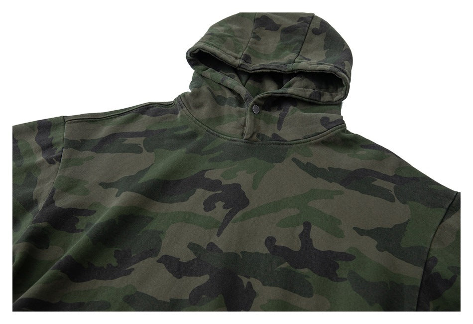 Front view of a green woodland camouflage hoodie with a hood and snap-button neckline.