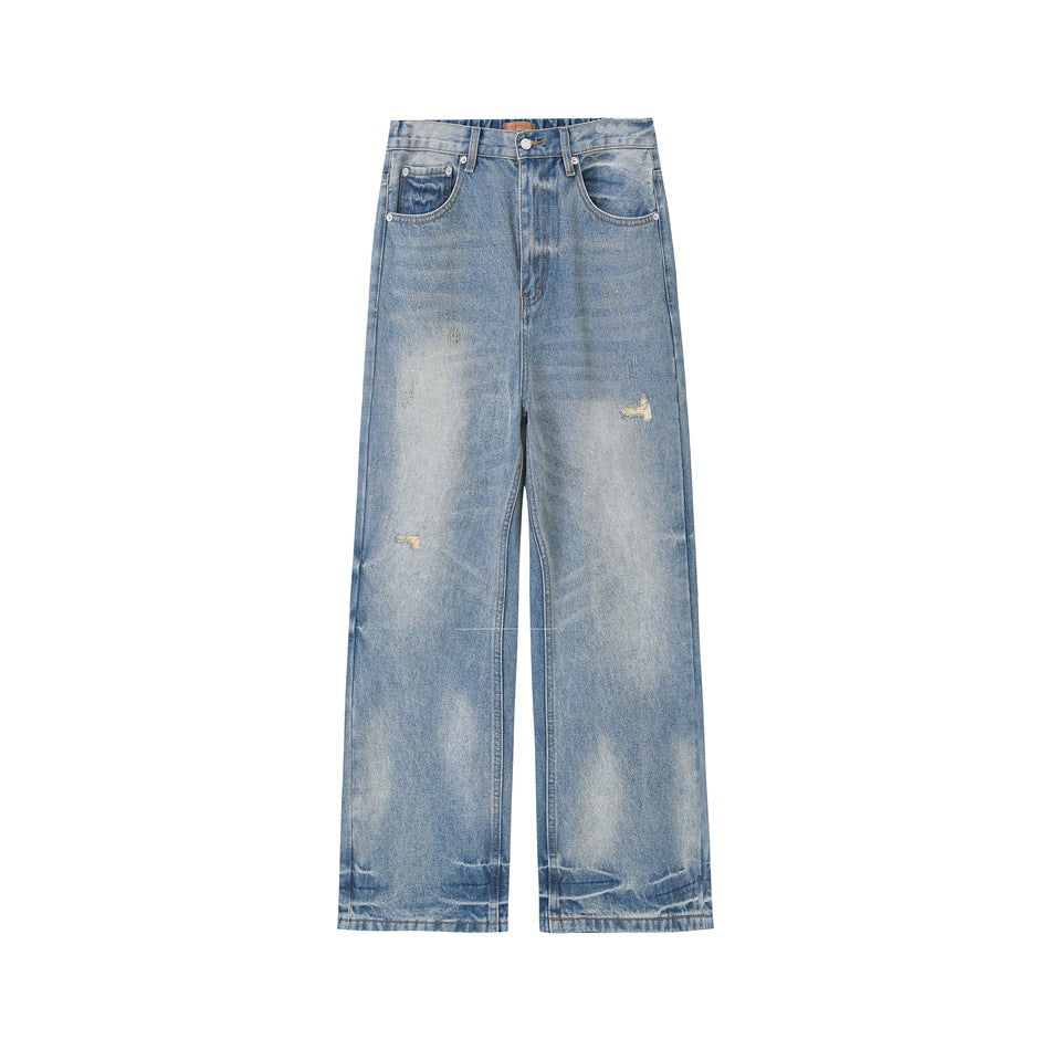 Front view of light blue washed wide-leg jeans with faded patches and small distressed spots on a white background