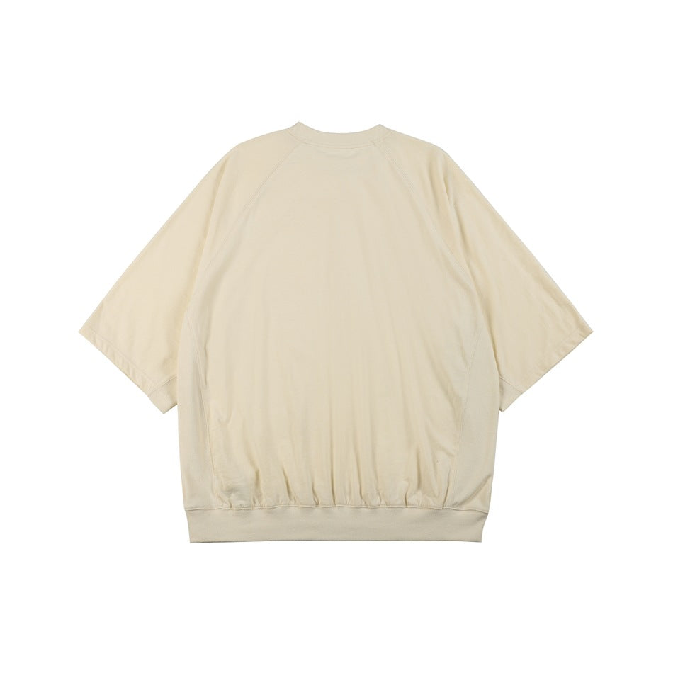Back view of a plain ivory short-sleeve sweatshirt with raglan seams and a ribbed hem.