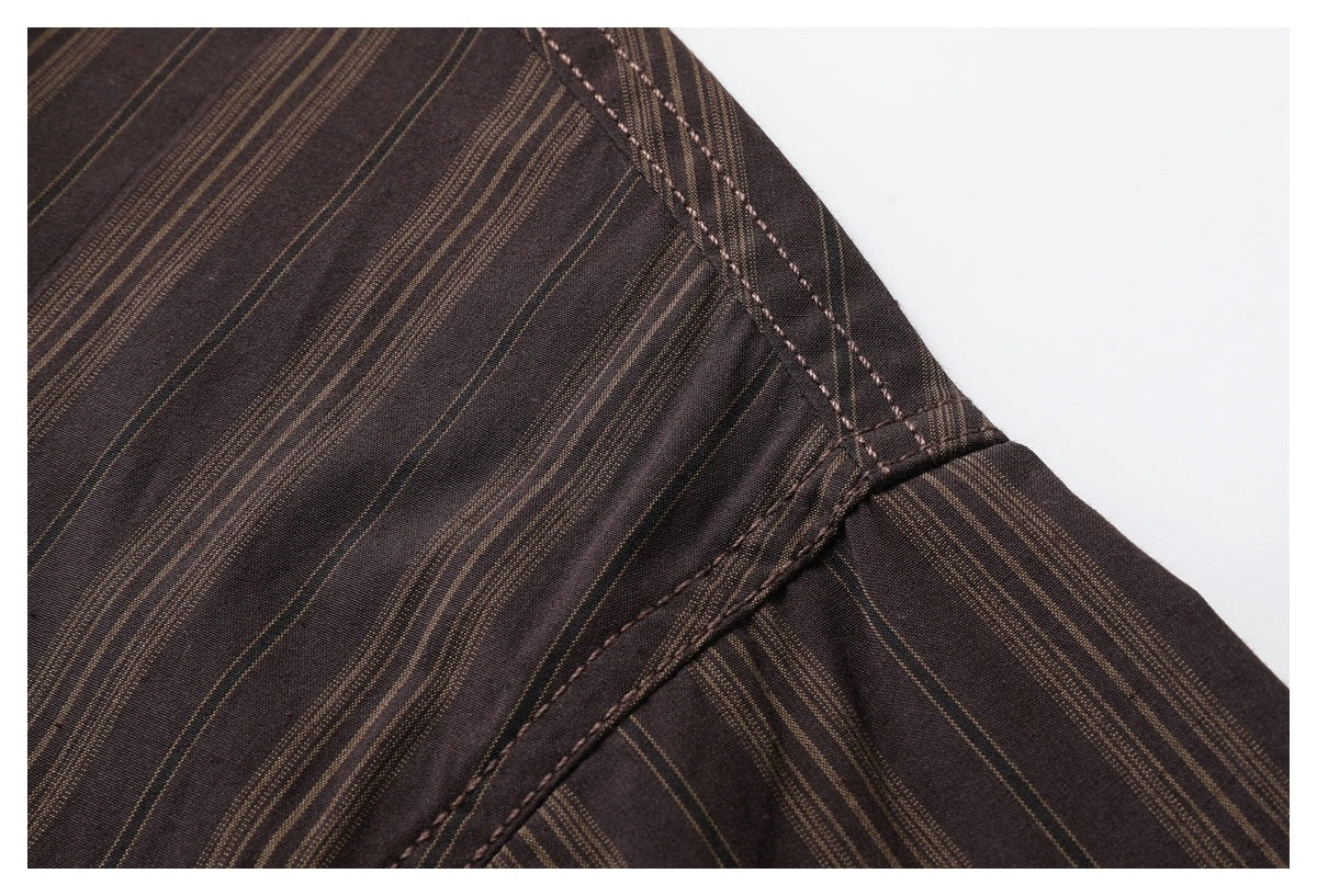 Close-up of the dark brown shirt's shoulder seam and fine tan vertical stripes.