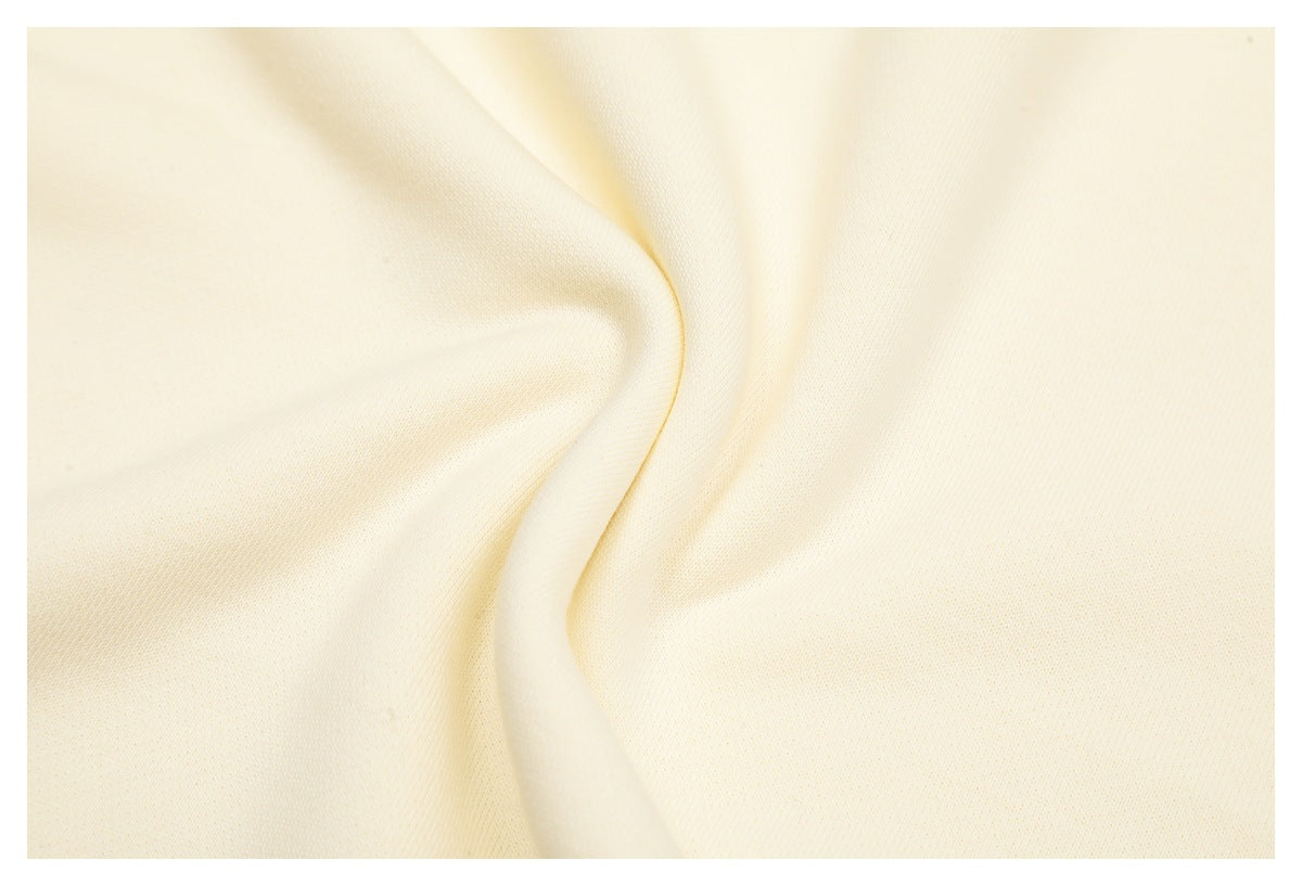 Close-up of plain cream sweatshirt fabric draped into soft folds.