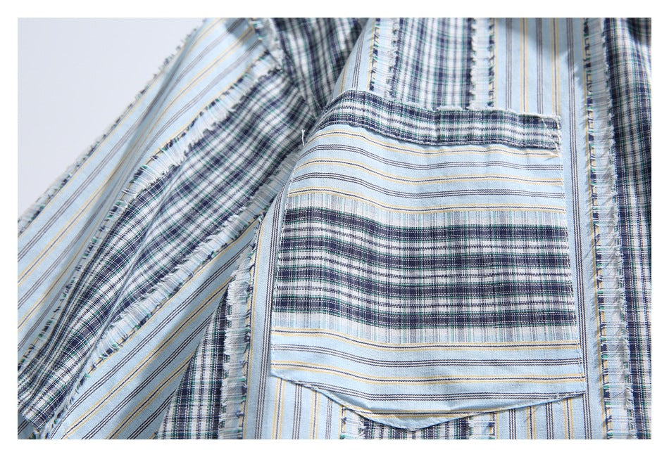 Close-up of a patch pocket on the shirt, with alternating blue-gray plaid and striped sections.
