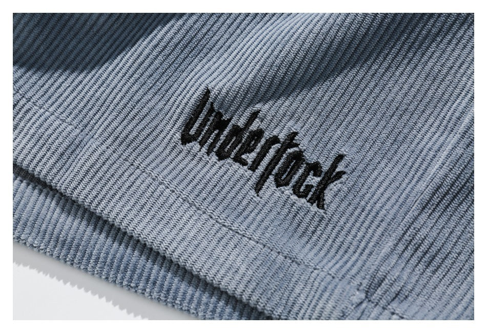 Close-up of black embroidered lettering on light blue ribbed fabric.