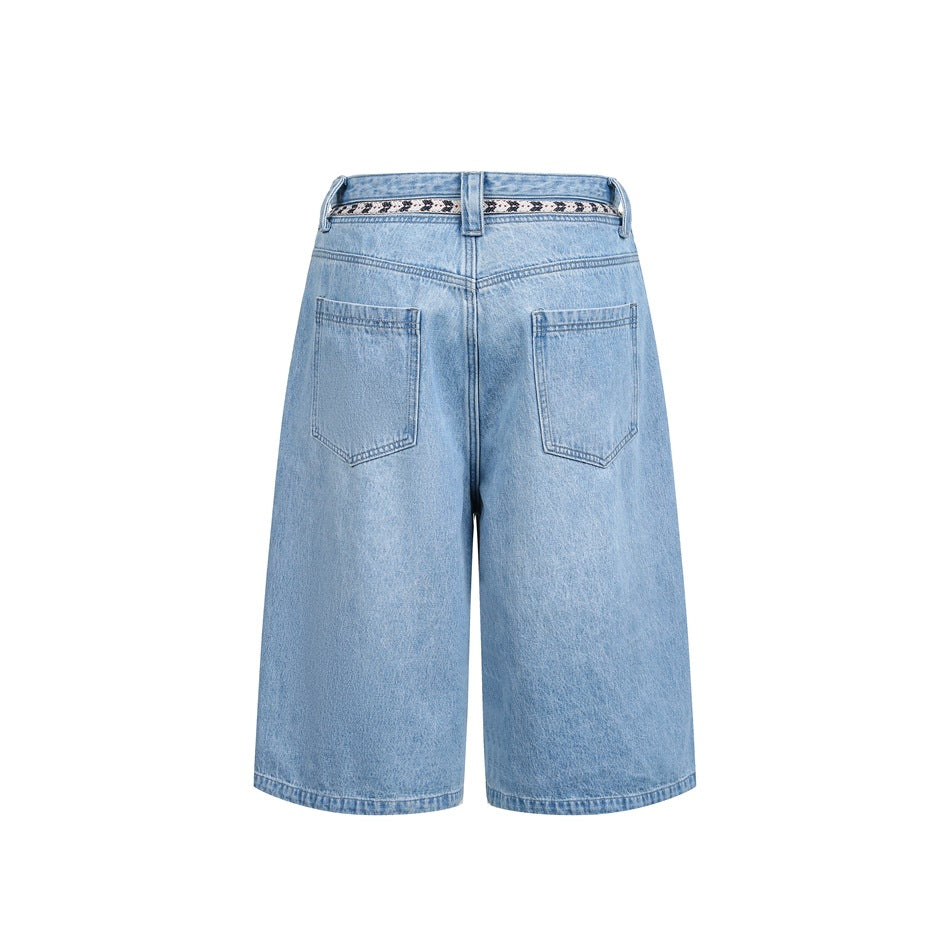 Back view of light blue denim knee-length shorts with two back pockets and a patterned waistband.