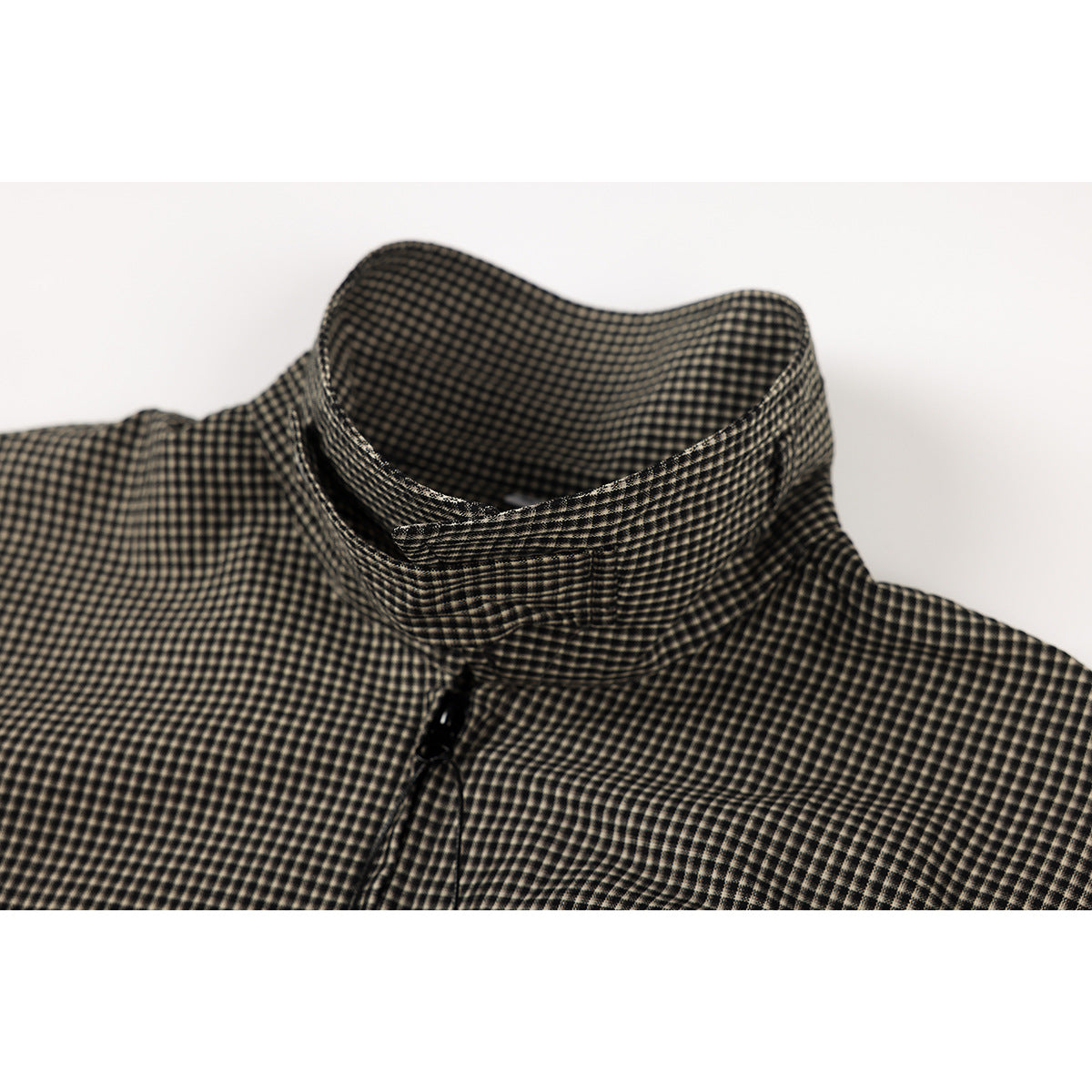 Close-up of a stand collar on a black and beige micro-check shirt.