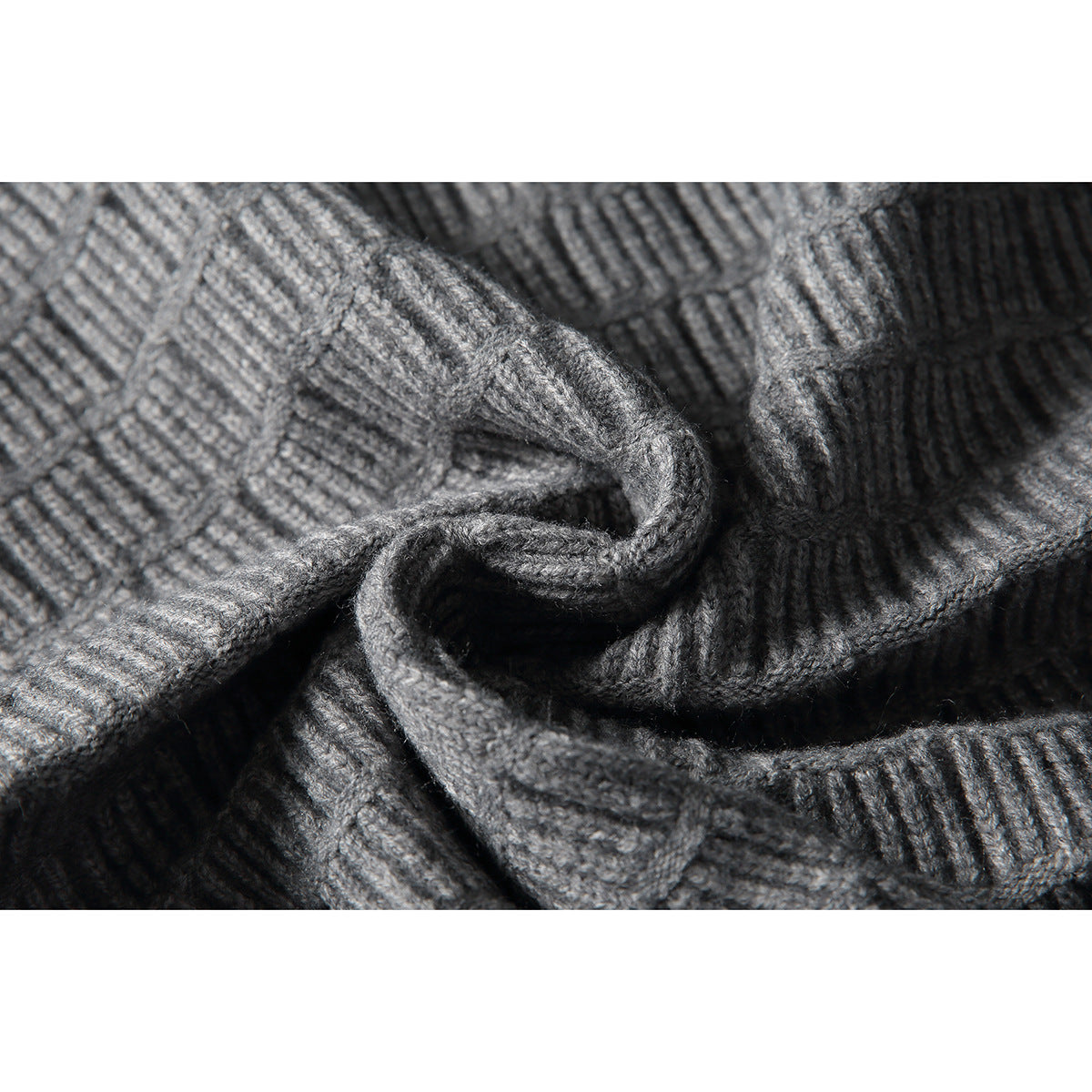Close-up of gray knit fabric gathered to show its raised texture and stitching.