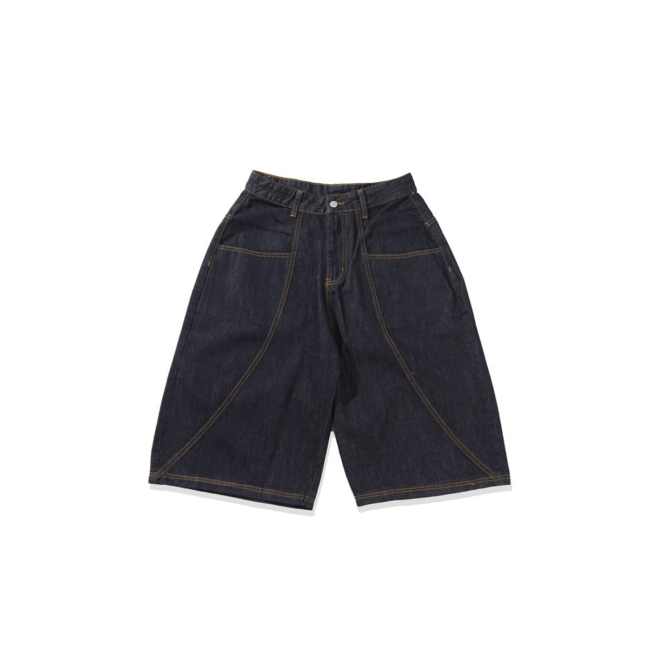 Front view of dark indigo denim shorts with wide legs, curved contrast stitching, and front pockets.