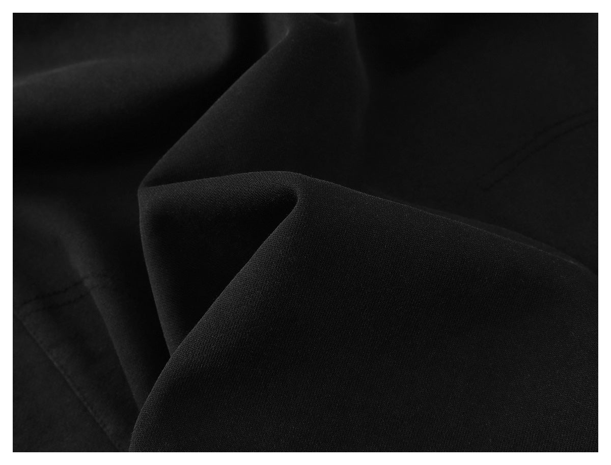 Close-up of smooth black fabric draped into soft folds.