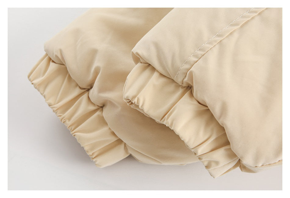 Close-up of gathered elastic cuffs on a cream garment.