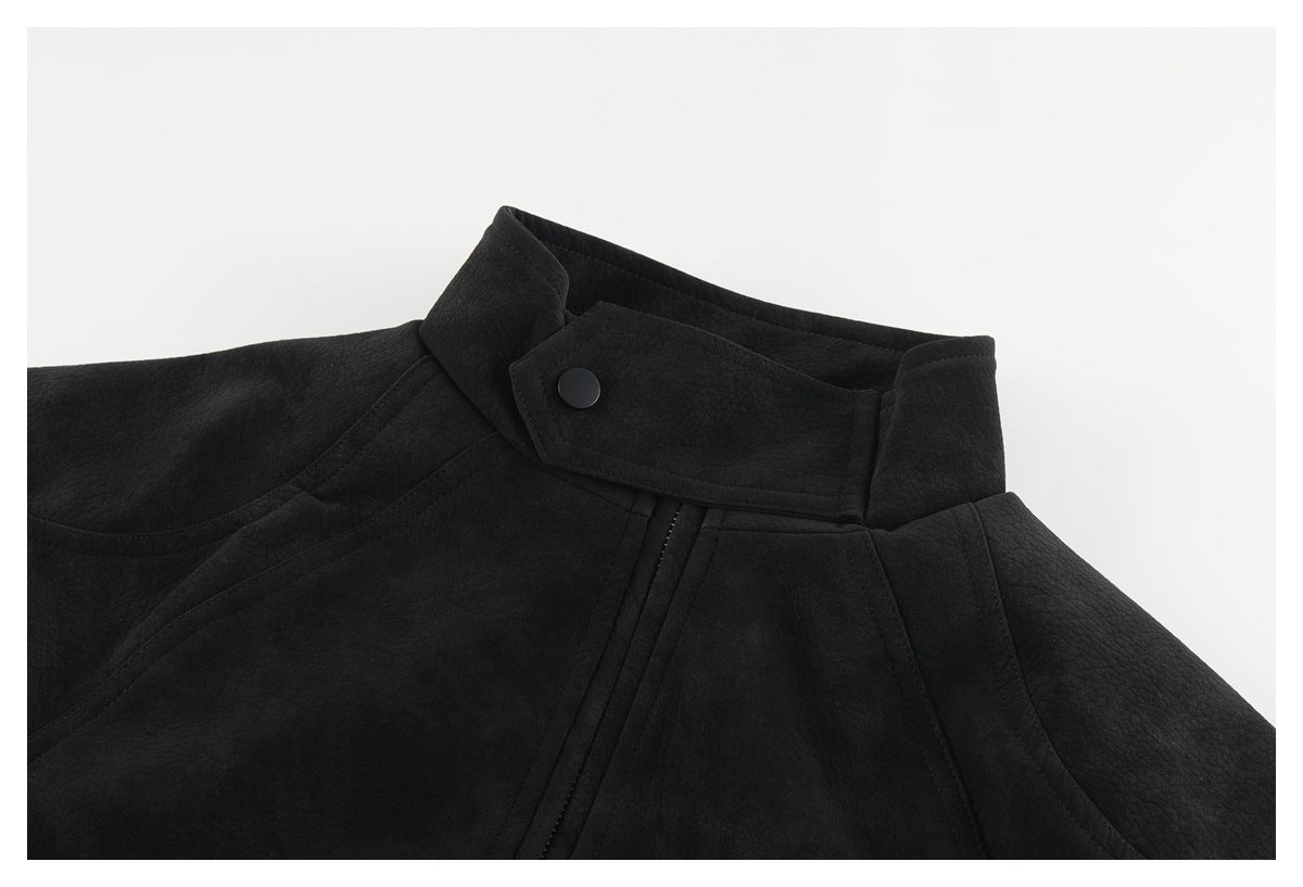 Close-up of a black jacket's stand collar, snap-fastened neck tab, and stitched front panels.