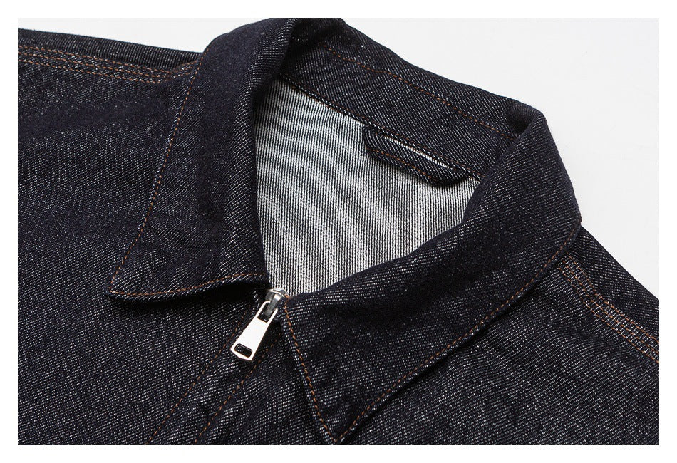 Close-up of the denim jacket's pointed collar, inner denim facing, orange stitching, and front zipper.