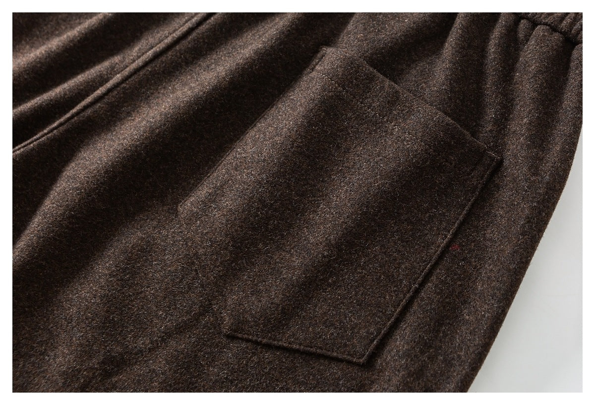Close-up of a rectangular patch pocket on dark brown pants.