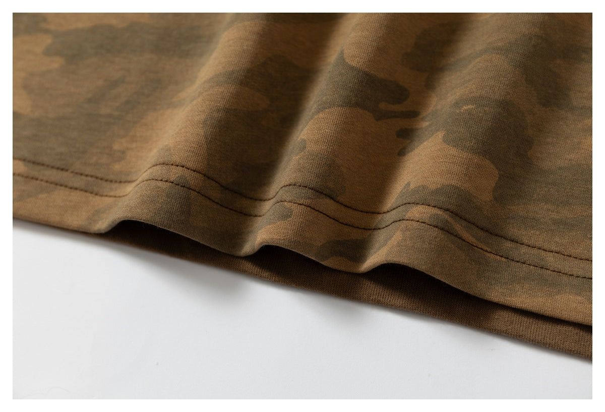 Close-up of the wavy stitched bottom hem on a brown camouflage garment.