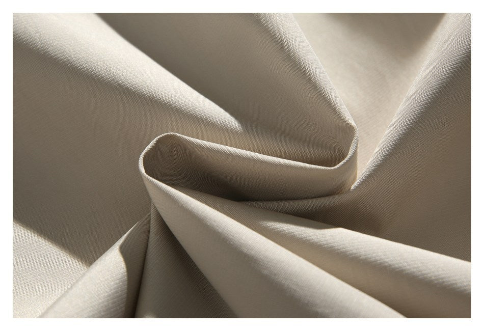 Close-up of softly folded cream fabric showing its fine surface texture.