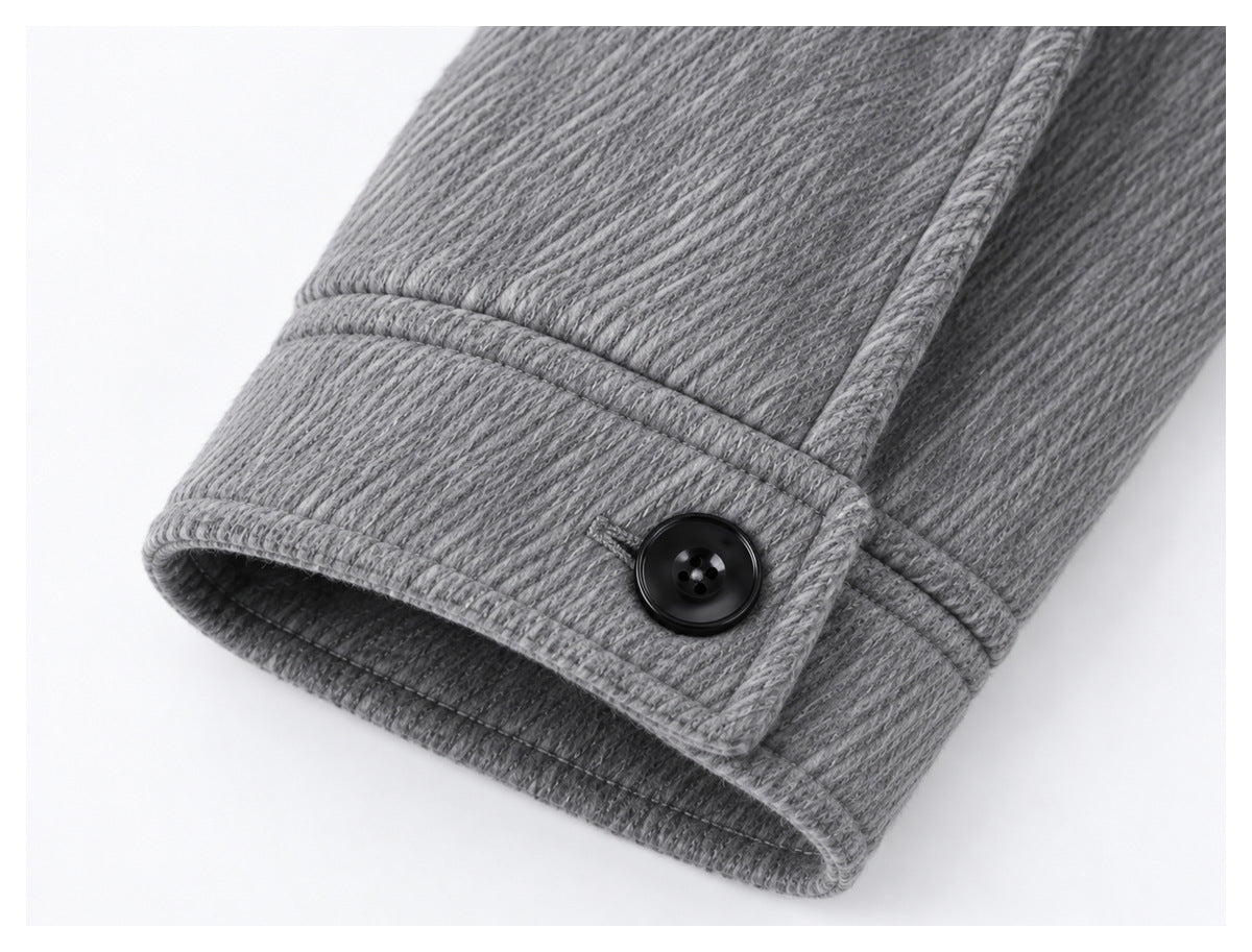 Close-up of the gray jacket sleeve cuff with a black button and stitched trim.