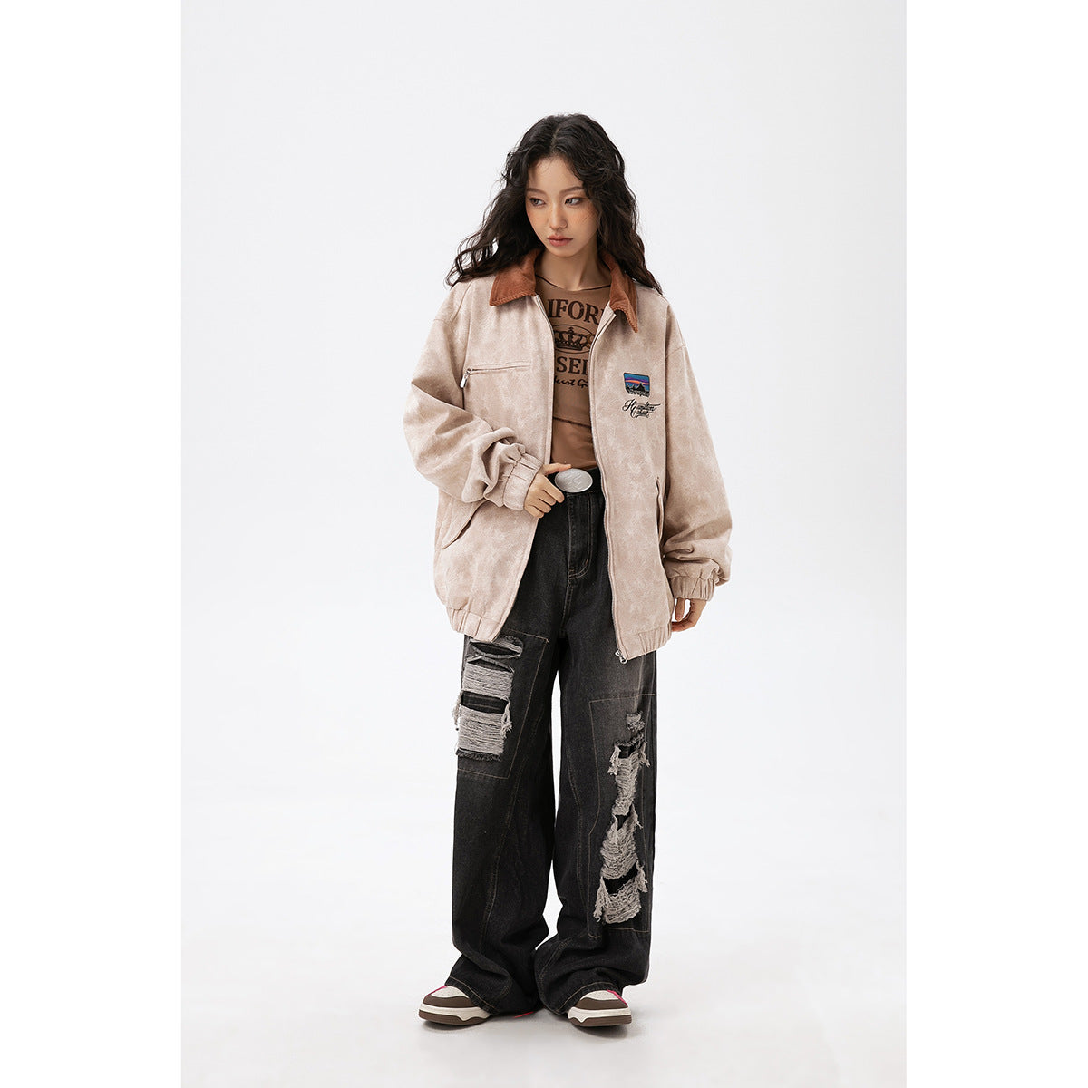 Model wearing an open light beige zip jacket with a brown collar and chest embroidery.