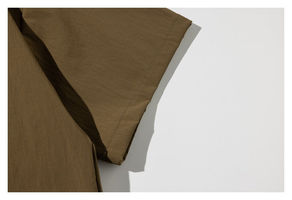 Close-up of the short sleeve and stitched hem of an olive-brown garment.