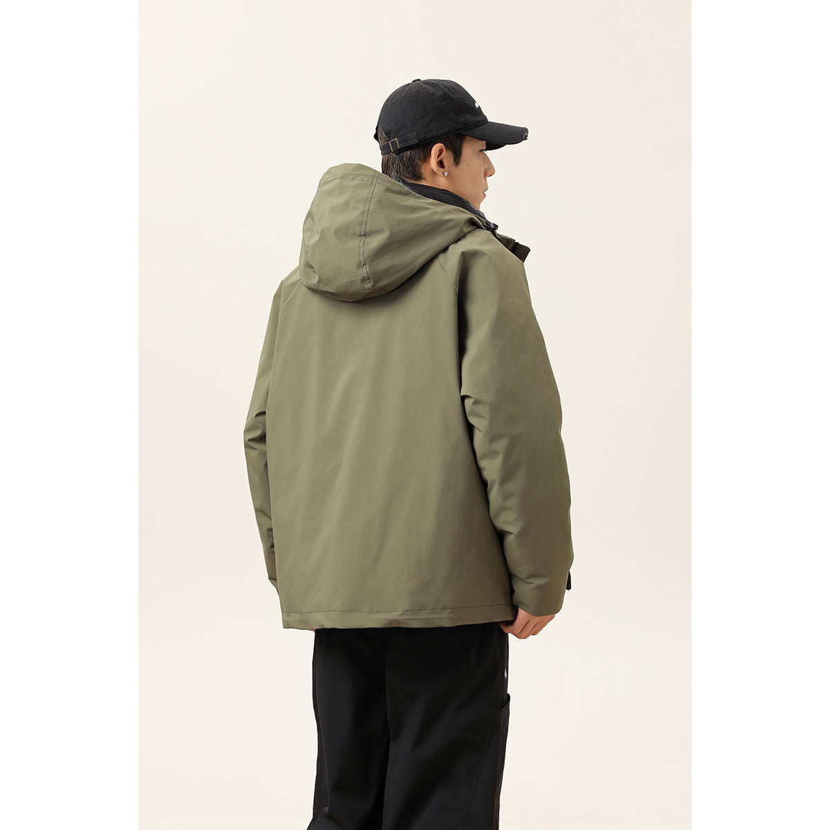 Rear view of a model wearing an olive hooded jacket with a plain back.