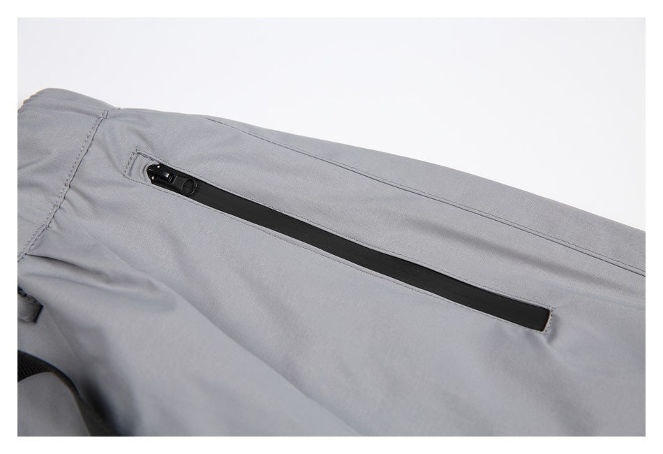Close-up of a long black zip pocket on light gray pants.