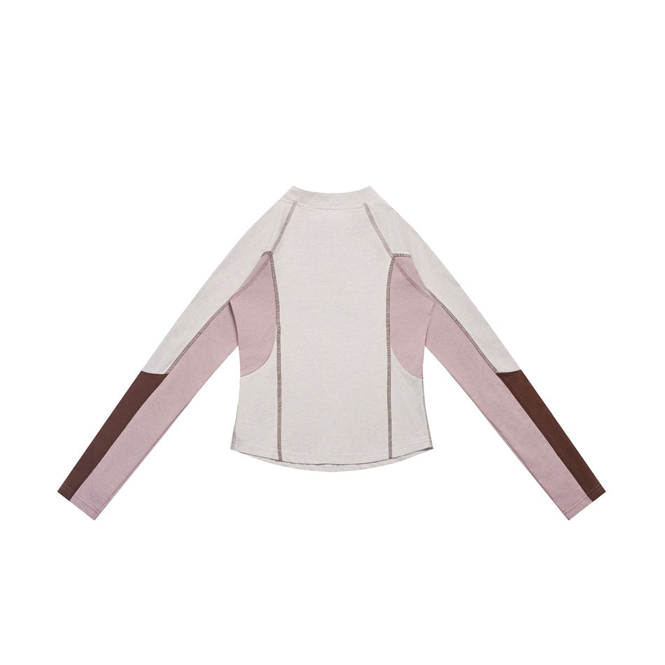 Back view of a pale top with pink side panels and sleeves, brown lower-sleeve blocks, and contrast seams.
